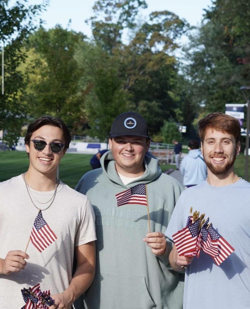 Three Kappa Sigma brothers holding American flags